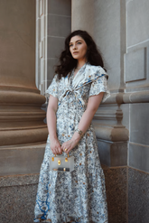 a lady in a blue floral print dress